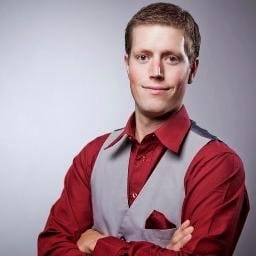 Mark Eyjolfson smiles at the camera with arms crossed.