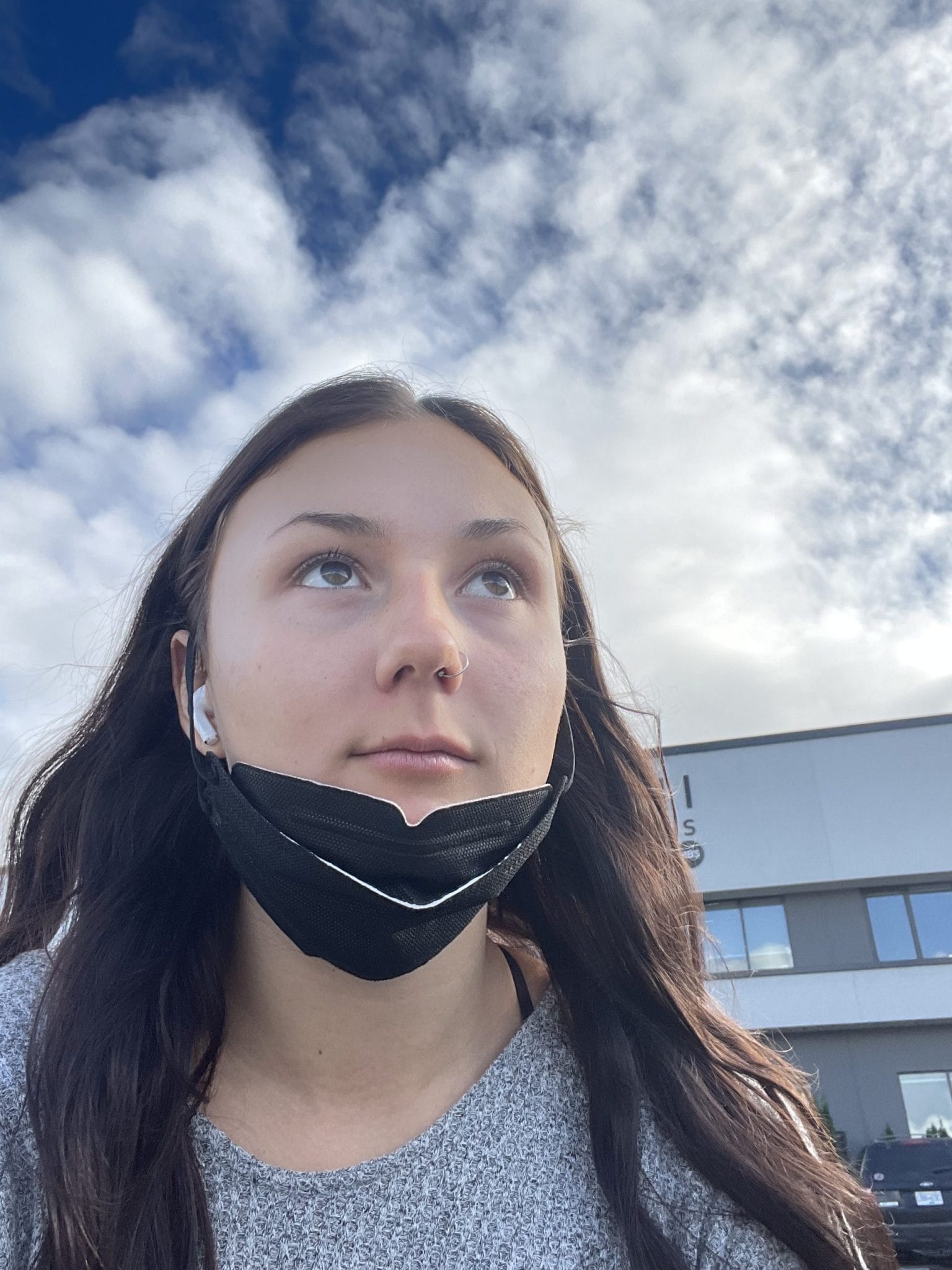 Shyla Walsh-Courchaine looks past the camera, medical mask pulled down to chin. 