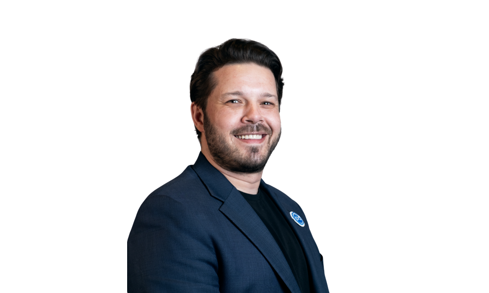 Headshot of a smiling man in a dark blue blazer.